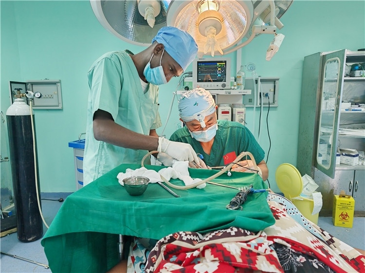 李廣醫(yī)生與當?shù)蒯t(yī)生在做手術中。中國援桑醫(yī)療隊供圖
