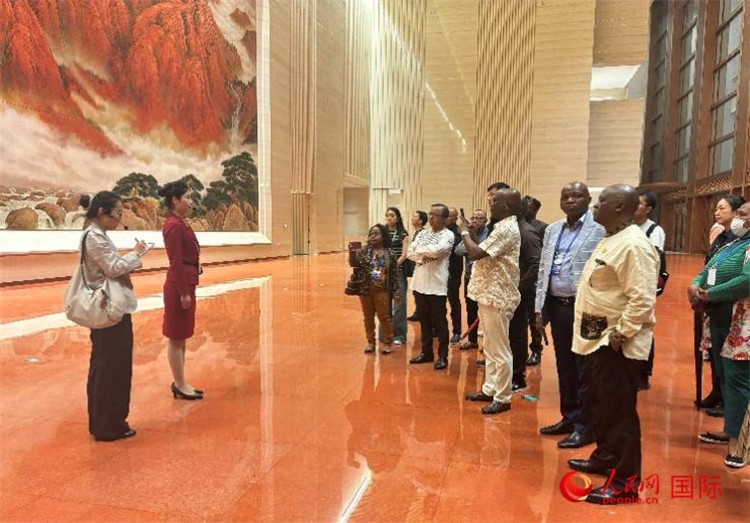 代表團在入口處聽取講解。人民網(wǎng) 曹欣悅攝