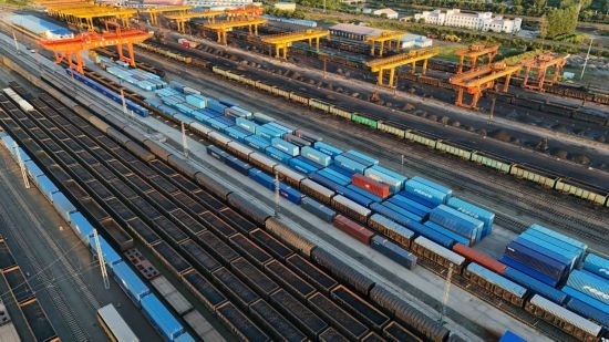 這是2024年8月14日在黑龍江綏芬河鐵路口岸集裝箱換裝場拍攝的集裝箱換裝作業(yè)現(xiàn)場（無人機(jī)照片）。今年前七個(gè)月，綏芬河鐵路口岸開行中歐班列573列，運(yùn)量達(dá)55246標(biāo)箱，同比分別增長23%和18%，班列數(shù)量持續(xù)保持高位運(yùn)行。