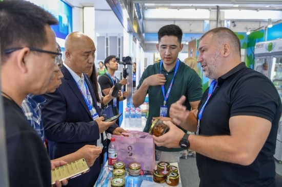 2023年8月23日，在第十四屆中國—東北亞博覽會(huì)東北亞商品館，俄羅斯參展商向參觀者介紹商品。