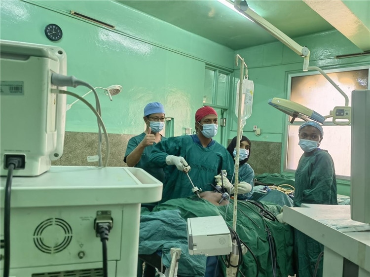 隊長蔣國慶（左一）關注當?shù)蒯t(yī)生手術情況。中國援桑醫(yī)療隊供圖