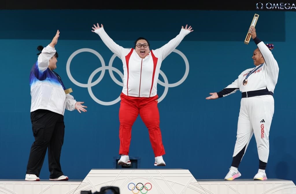 中國(guó)選手李雯雯（中）在巴黎奧運(yùn)會(huì)舉重女子81公斤以上級(jí)頒獎(jiǎng)儀式中登上領(lǐng)獎(jiǎng)臺(tái)（2024年8月11日攝）。新華社記者 楊磊 攝