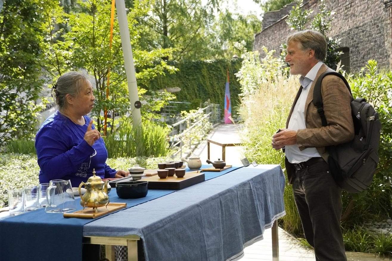 在博物館的戶外花園來賓品味中國茶藝。比利時(shí)維他命文化傳媒供圖