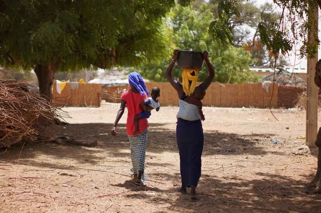 2023年3月20日，在塞內(nèi)加爾久爾貝勒區(qū)的泰內(nèi)富勒村，村民將取到的水運(yùn)回家。新華社記者 王子正 攝