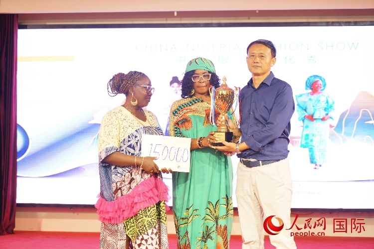 中國(guó)駐尼日利亞使館文化參贊兼中國(guó)文化中心主任李旭大（右）為最佳表現(xiàn)獎(jiǎng)?lì)C獎(jiǎng)（中）。人民網(wǎng)記者 姜宣攝