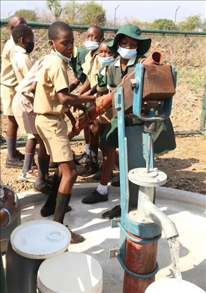 △2021年11月，在津巴布韋南馬塔貝萊蘭省省會(huì)關(guān)達(dá)的塞農(nóng)多小學(xué)，學(xué)生從中國(guó)援建水井里打水。