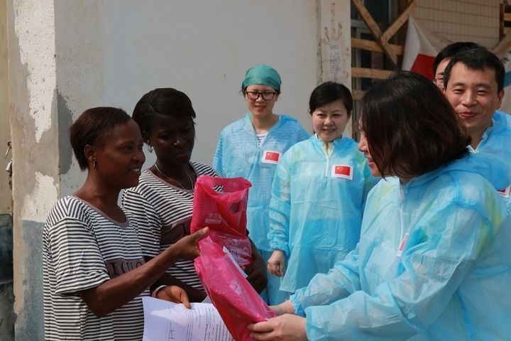 2015年4月4日，在位于塞拉利昂首都弗里敦市郊的中塞友好醫(yī)院埃博拉診療中心，中國第四批援塞醫(yī)療隊(duì)副隊(duì)長邵蔚（右前）向被治愈的埃博拉出血熱患者贈送禮物。新華社發(fā)（祖榮強(qiáng) 攝）
