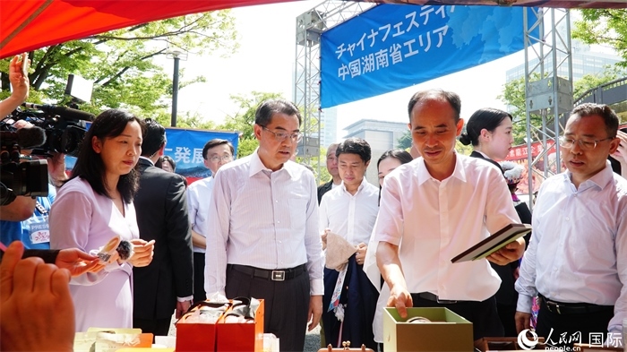 湖南展位工作人員向中國(guó)駐日本大使吳江浩介紹特色文創(chuàng)產(chǎn)品。人民網(wǎng) 蔣曉辰攝