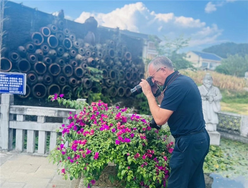 遠(yuǎn)處黔北民居錯(cuò)落有致，近處一只黑色的蝴蝶穿梭于粉紫色三角梅花叢間隙，與俄羅斯“大歐亞”總編輯弗拉基米爾·別列日內(nèi)赫的鏡頭玩起了捉迷藏，“你追我逃，不亦樂(lè)乎”。（張亞欣攝）