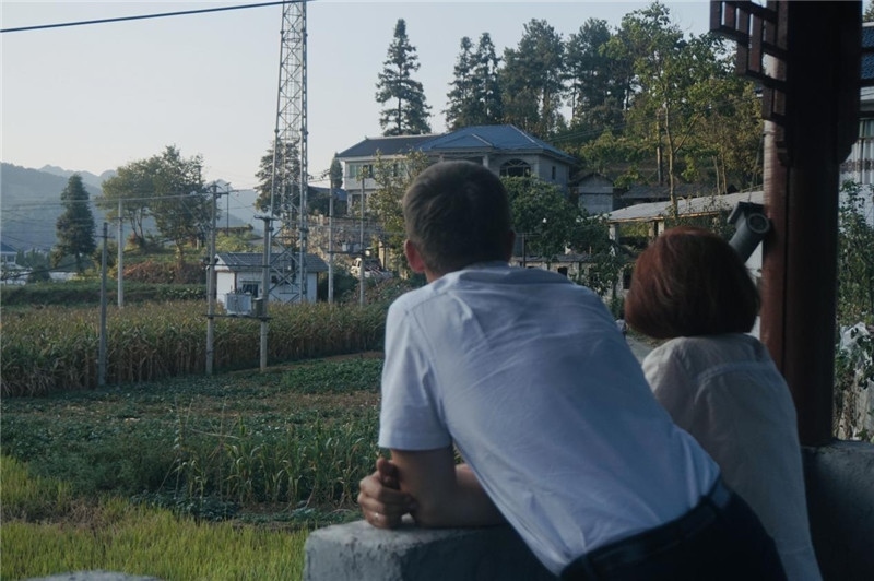 望得見(jiàn)山，看得見(jiàn)水，記得住鄉(xiāng)愁。每個(gè)人心中都有一個(gè)屬于自己的“花茂村”，在這方心田，走遍千山萬(wàn)水，鄉(xiāng)音未改鬢毛衰。吉爾吉斯斯坦《比什凱克晚報(bào)》第一副總編輯妮娜·尼奇博洛娃與《中國(guó)與俄羅斯》雜志社社長(zhǎng)奧列格·別列日內(nèi)赫攝在花茂村民居屋檐下并肩佇立，眺望山水，尋覓鄉(xiāng)愁。（李光裕攝）