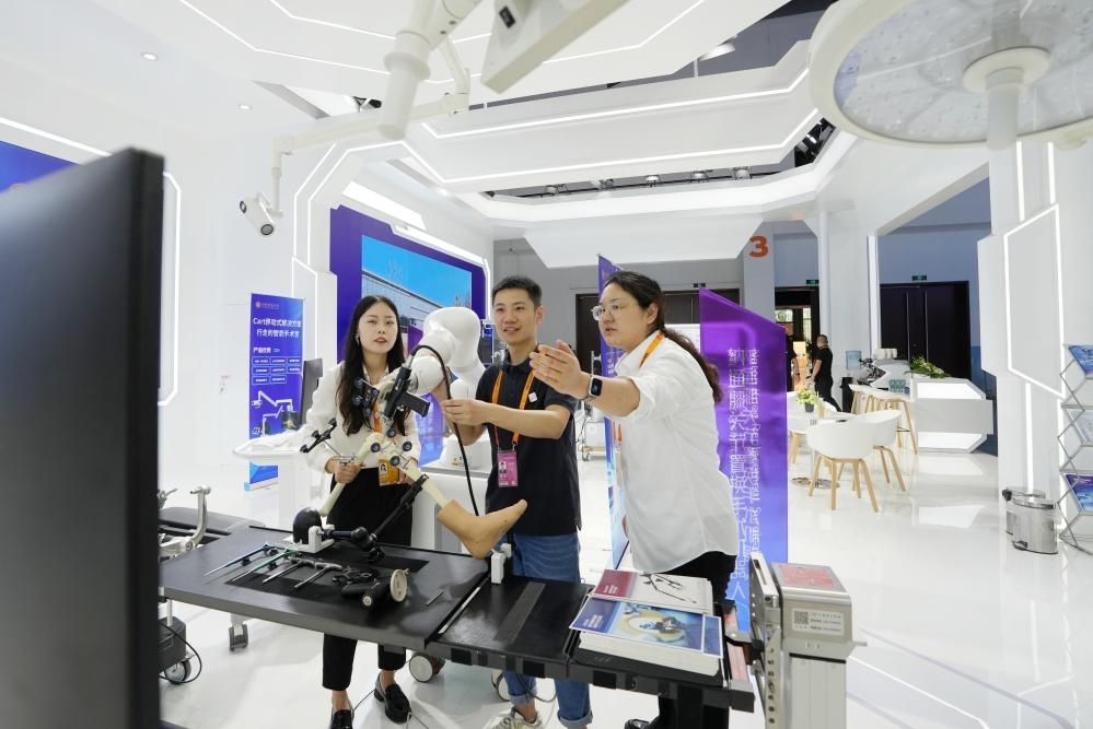 9月11日，一位媒體記者（中）在2024年服貿(mào)會國家會議中心會場體驗北京納通科技集團(tuán)有限公司的膝關(guān)節(jié)置換手術(shù)機(jī)器人。新華社記者鞠煥宗 攝