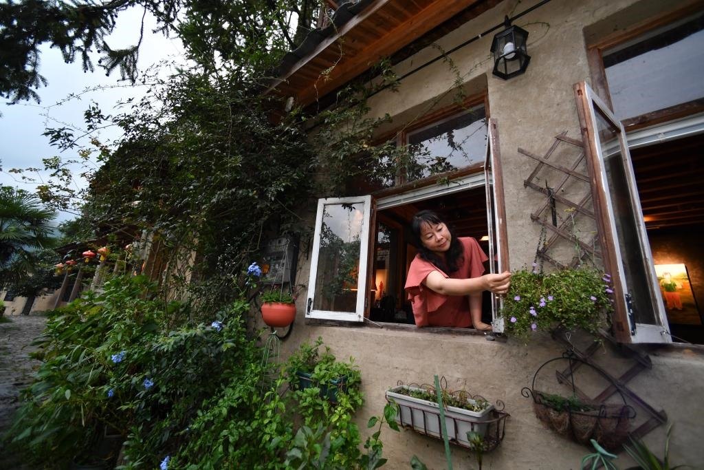 8月29日，在福建省屏南縣熙嶺鄉(xiāng)，龍?zhí)洞濉靶麓迕瘛泵泛暝诖蚶碜约航洜I的民宿外墻裝飾花盆。新華社記者姜克紅 攝