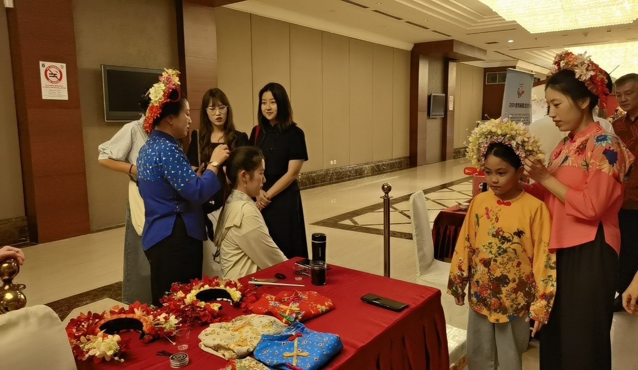 阿拉扎大學(xué)孔子學(xué)院志愿者老師向傳承人學(xué)習(xí)簪花圍。阿拉扎大學(xué)孔子學(xué)院供圖