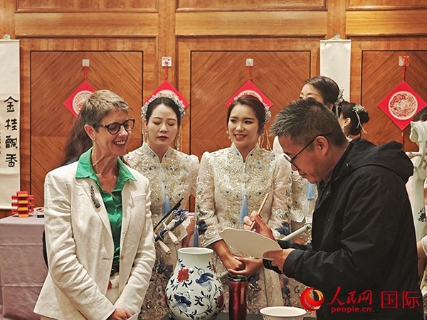 現(xiàn)場(chǎng)的非遺傳承人為英國(guó)觀眾展示畫技。人民網(wǎng)記者 邢雪攝