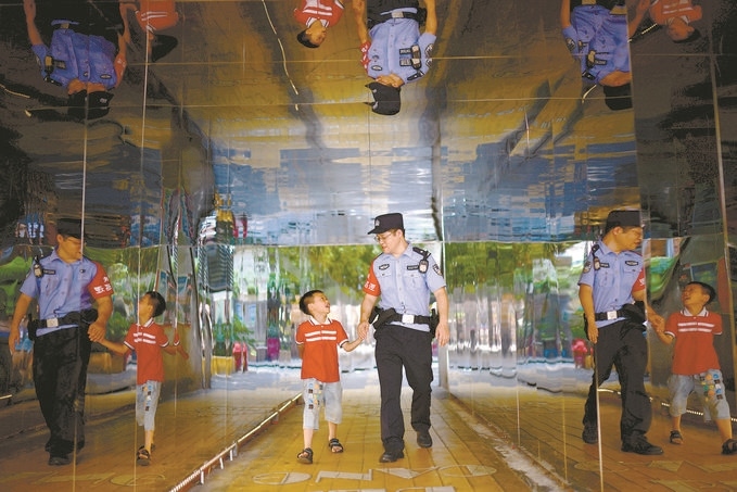 ?7月16日，重慶市公安局江北區(qū)分局一名民警在巡邏途中遇到一個(gè)獨(dú)自玩耍的小男孩，民警將其送回家。王洪平攝