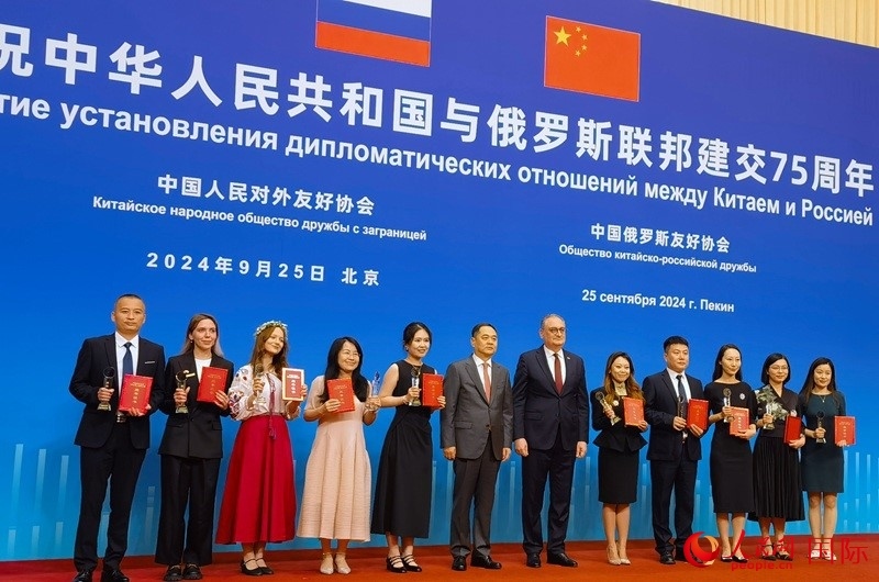 楊萬明會長和莫爾古洛夫大使為10位中俄青年友好微視頻創(chuàng)意大賽獲獎代表頒獎。人民網(wǎng)記者 李明琪攝