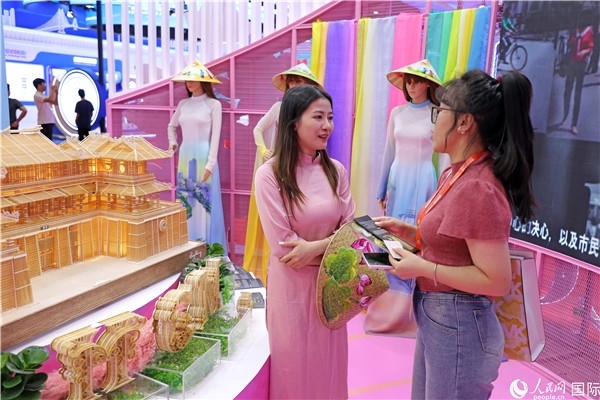 參觀者在東博會越南展區(qū)同工作人員咨詢交談。人民網(wǎng)記者 趙益普攝