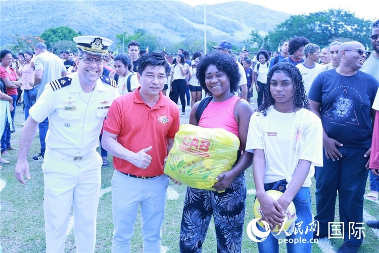 巴西中國浙江商會會長鄭俠茂向巴西貧困社區(qū)兒童及家庭捐贈基礎(chǔ)食品籃子和足球。人民網(wǎng)記者陳海琪 攝