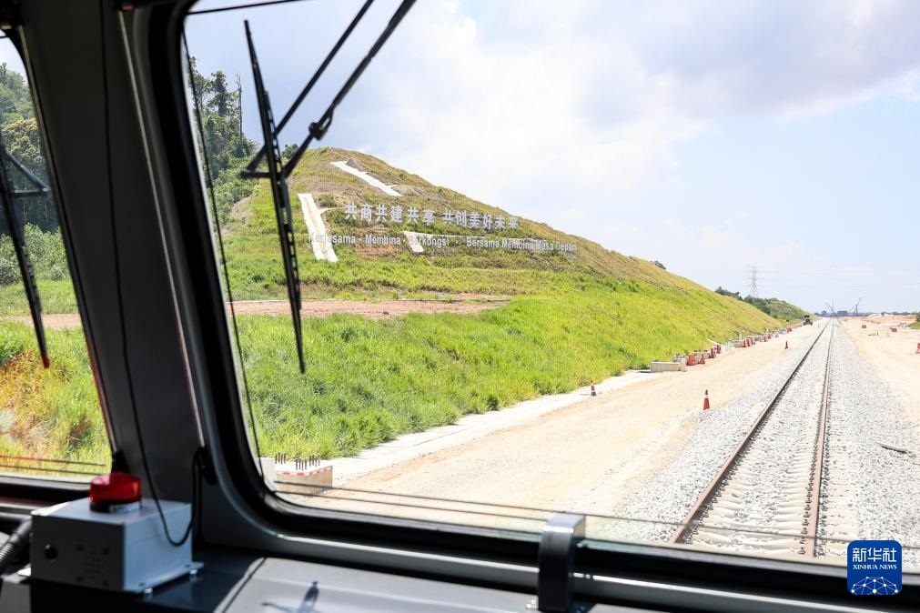 5月6日，在馬來西亞彭亨州馬東鐵項(xiàng)目沿途的山坡上，兩行中文和馬來文大字“共商共建共享，共創(chuàng)美好未來”映入眼簾。新華社記者 程一恒 攝