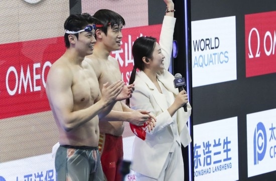 10月18日，汪順（左）和潘展樂在男子100米混合泳決賽后。新華社記者 方喆 攝