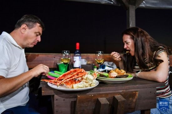 9月2日，食客們在俄羅斯符拉迪沃斯托克的一家餐館品嘗帝王蟹。新華社記者 曹陽 攝