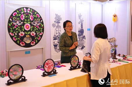 青海非遺文化傳承人向嘉賓介紹展品。人民網(wǎng)實習(xí)生姚欣可攝