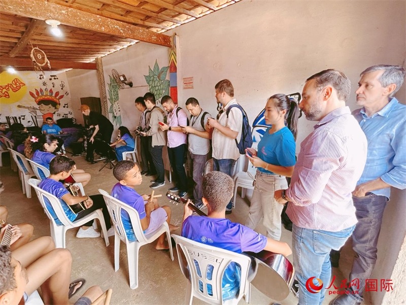  受益于中國企業(yè)的“青少年成長”項目，700多名當?shù)厍嗌倌甑囊魳泛妥闱驂粝氩迳狭顺岚?。圖為聯(lián)合采訪團正在采訪參加音樂培訓的孩子們。 人民網(wǎng)記者 陳一鳴攝