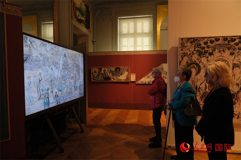 觀眾在展臺(tái)觀看錄像講解。人民網(wǎng)記者 尚凱元攝