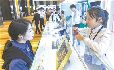 在北京麗澤商務(wù)區(qū)，工作人員（右一）介紹數(shù)字人民幣SIM卡硬錢包。新京報記者 陶冉攝