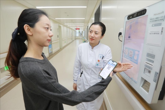 醫(yī)護(hù)人員引導(dǎo)患者在自助機(jī)前辦理自助入院手續(xù)。圖片來(lái)源：山東第一醫(yī)科大學(xué)第二附屬醫(yī)院