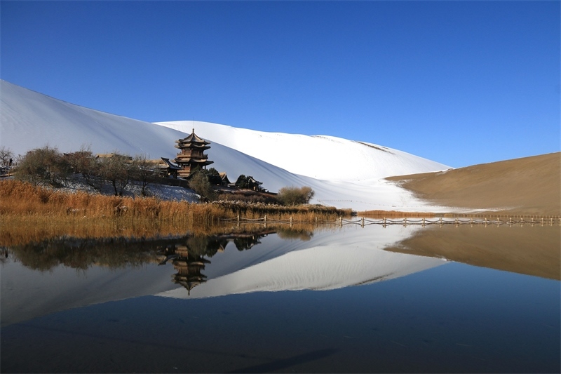 鳴沙山月牙泉景區(qū)雪景。敦煌市委宣傳部供圖，張曉亮攝