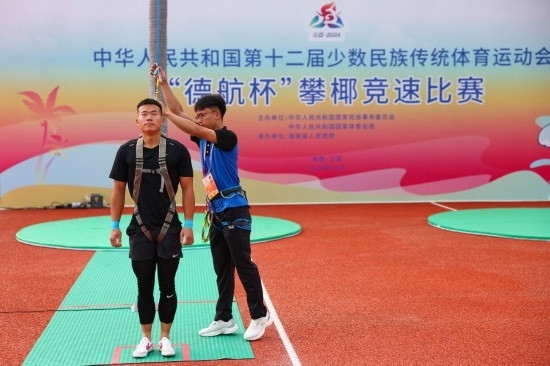 11月23日，工作人員為上海隊(duì)選手付樂樂（左）系安全繩。新華社記者 楊植森 攝