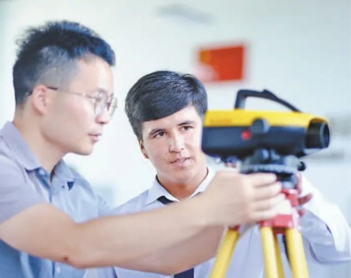 在塔吉克斯坦首都杜尚別的魯班工坊，來(lái)自天津城市建設(shè)管理職業(yè)技術(shù)學(xué)院的老師（左）為當(dāng)?shù)貙W(xué)生提供指導(dǎo)。新華社記者 鄭開(kāi)君 攝