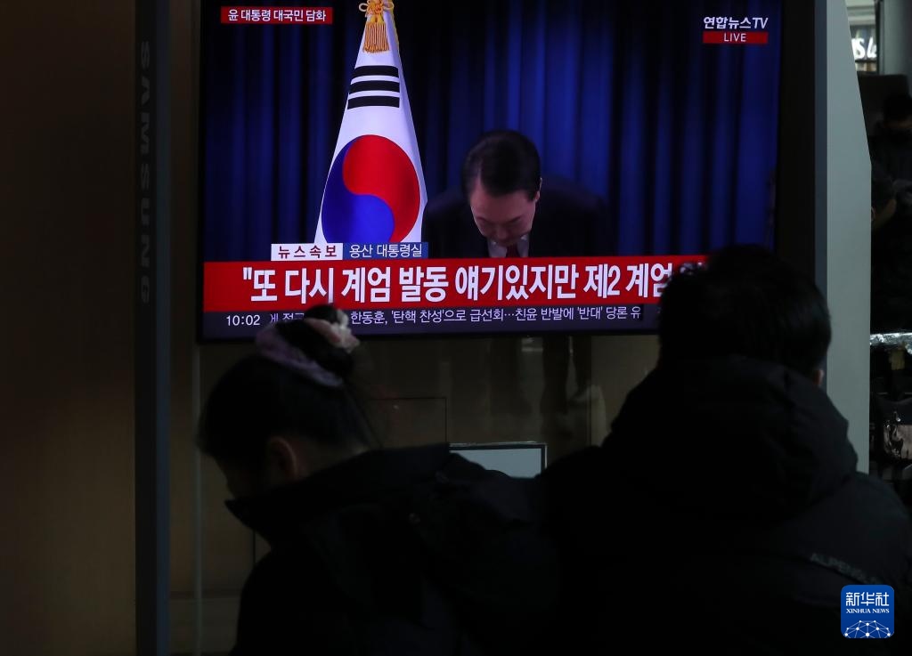 12月7日，在韓國(guó)首爾火車站，民眾觀看總統(tǒng)尹錫悅發(fā)表講話的電視畫(huà)面。新華社記者 姚琪琳 攝