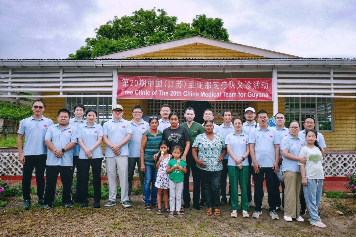 第20期中國(guó)（江蘇）援圭亞那醫(yī)療隊(duì)在圭偏遠(yuǎn)的林登高速社區(qū)開(kāi)展義診后，與部分當(dāng)?shù)鼐用窈嫌啊?中國(guó)援圭醫(yī)療隊(duì)供圖