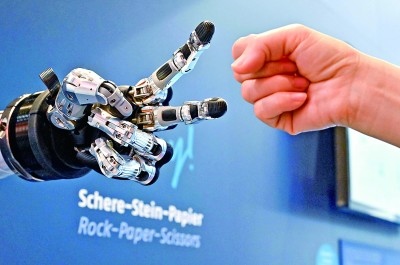 在德國漢諾威工博會(huì)上，參觀者與一款智能機(jī)器人進(jìn)行“石頭剪子布”游戲。新華社發(fā)