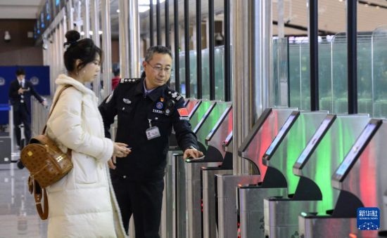 1月2日，大興機(jī)場(chǎng)邊檢站警察指導(dǎo)旅客使用自助出境設(shè)備。新華社記者 李欣 攝
