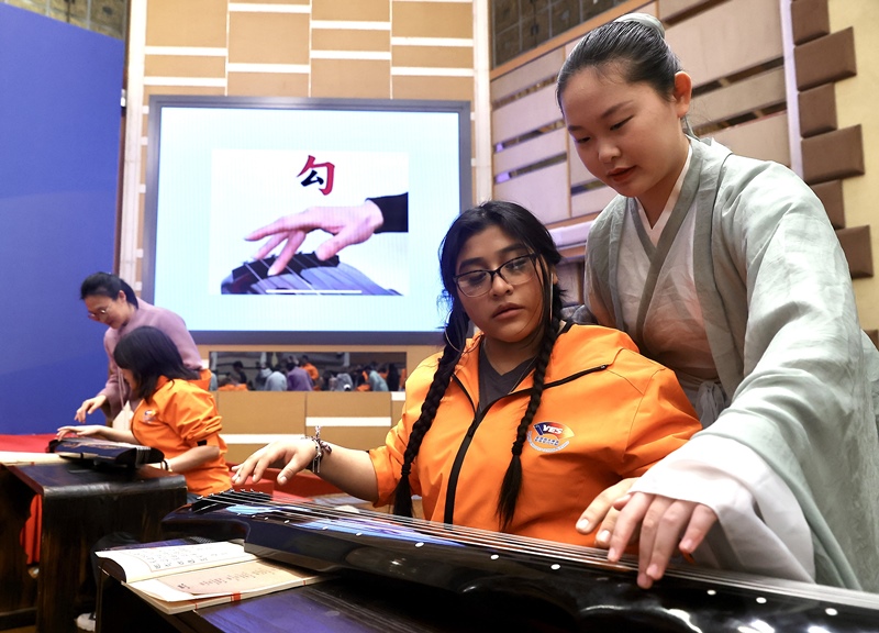 2024年3月20日，美國華盛頓州中學(xué)生代表團(tuán)北京大學(xué)交流活動在北京大學(xué)英杰交流中心舉行。圖為來自華盛頓州的中學(xué)生體驗(yàn)古琴。