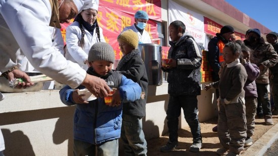 1月14日，廚師們正在給前來用餐的小朋友們打飯。新華社記者 邱星翔 攝