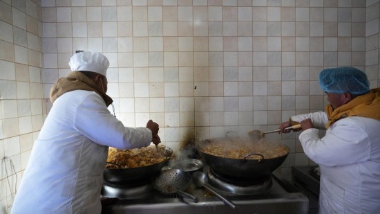 1月14日，服務(wù)隊的兩名廚師正在為村民們做午飯。新華社記者 邱星翔 攝