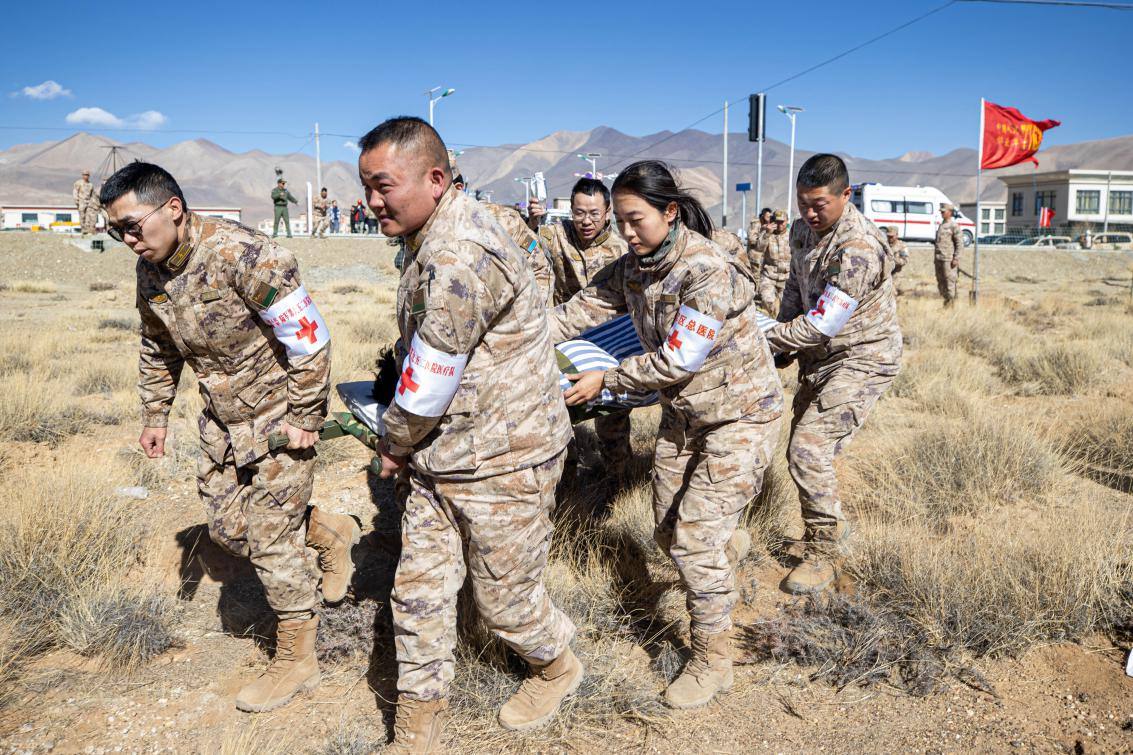 1月9日，日喀則定日縣長所鄉(xiāng)，西藏軍區(qū)總醫(yī)院醫(yī)療隊(duì)隊(duì)員將受傷村民用擔(dān)架從救護(hù)車準(zhǔn)備抬上直升機(jī)，轉(zhuǎn)運(yùn)至拉薩的西藏軍區(qū)總醫(yī)院救治。人民日?qǐng)?bào)記者張武軍攝