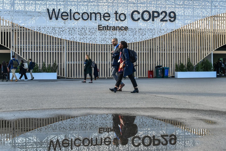 2024年11月15日，在阿塞拜疆首都巴庫，人們經(jīng)過聯(lián)合國氣候變化巴庫大會的會場。新華社記者 曹陽 攝