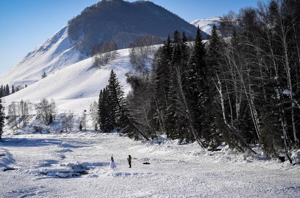 2024年2月5日，兩名游客在新疆阿勒泰地區(qū)布爾津縣禾木村拍照。新華社記者 馬鍇 攝