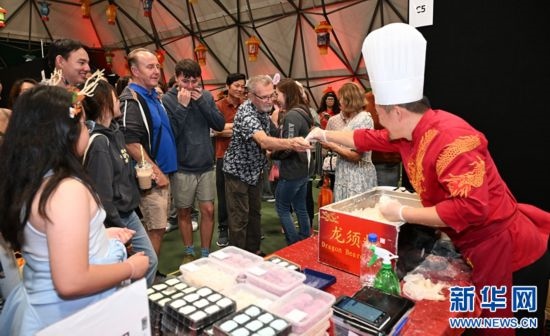 圖為游客在燈節(jié)現(xiàn)場(chǎng)購(gòu)買小吃。（圖片由奧克蘭中國(guó)文化中心提供）