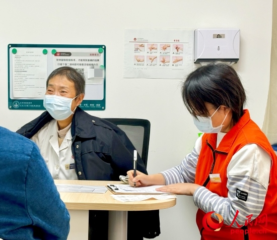 秦苑（中）接診患者。人民網(wǎng)記者 金慧慧攝