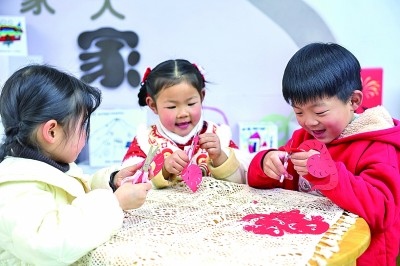 圖為孩子們在老師指導(dǎo)下制作蛇年主題剪紙。 新華社記者 徐昱攝