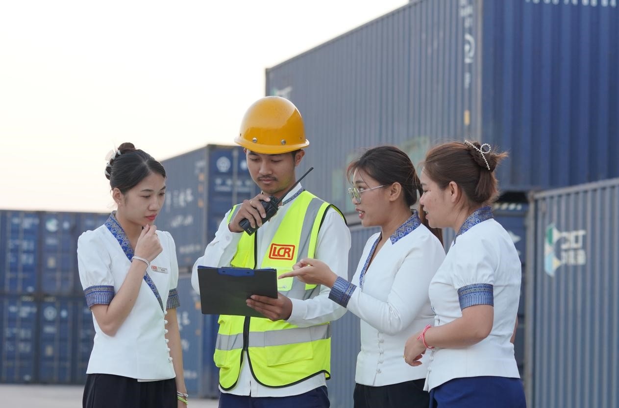 萬(wàn)象南站貨運(yùn)值班員陳尼啦（左一）與同事在一起討論工作。老中鐵路有限公司供圖