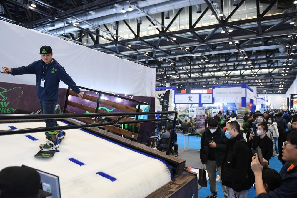 2023年2月11日，參觀者在展會上了解一款模擬滑雪設(shè)備。當(dāng)日，2023亞洲運(yùn)動用品與時尚展在國家會議中心拉開帷幕。新華社記者 張晨霖 攝
