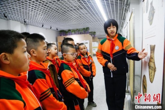 圖為學(xué)生通過(guò)展板了解出土于青海省海東市樂(lè)都區(qū)的辛店文化文物鹿紋彩陶甕。中新社記者 馬銘言 攝