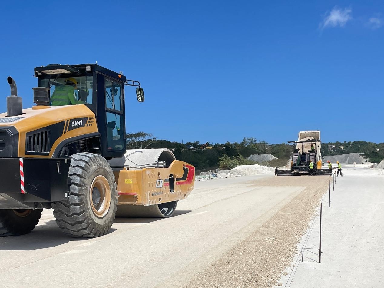 圖為中企承建的牙買(mǎi)加蒙特哥貝繞城路項(xiàng)目基層試驗(yàn)段正在進(jìn)行攤鋪和碾壓施工，相關(guān)施工工作已于日前順利完成。中國(guó)港灣美洲區(qū)域公司供圖